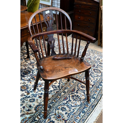 960 - A 19th century yew and elm Windsor hoop back elbow chair, raised on turned legs united by a crinolin... 