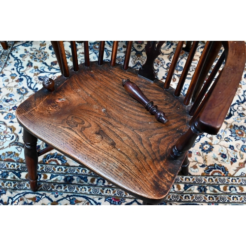 960 - A 19th century yew and elm Windsor hoop back elbow chair, raised on turned legs united by a crinolin... 