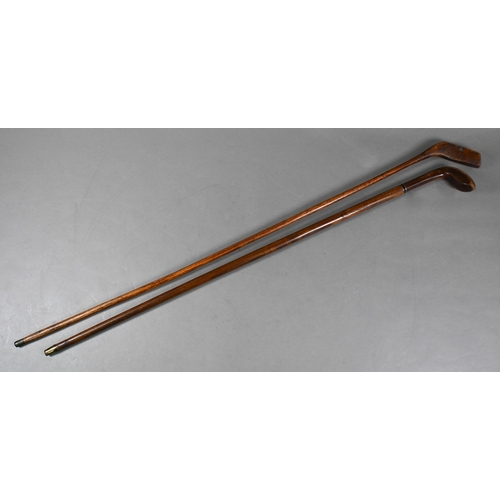 1081 - Two vintage hickory-shafted golf putters/walking sticks with lead-weighted heads and brass tips, 95/... 