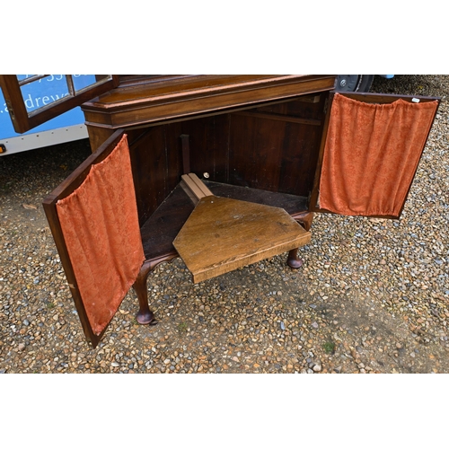 39 - # An Edwardian floor standing corner cabinet with glazed doors enclosing shelves, raised on pad-foot... 