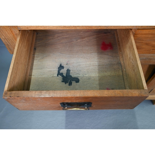 216 - An early 20th century Arts & Crafts mirror backed oak sideboard, the bevel edged plate flanked b... 