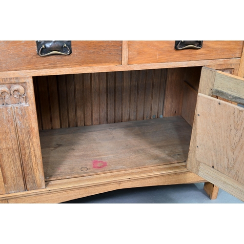 216 - An early 20th century Arts & Crafts mirror backed oak sideboard, the bevel edged plate flanked b... 