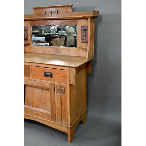 216 - An early 20th century Arts & Crafts mirror backed oak sideboard, the bevel edged plate flanked b... 