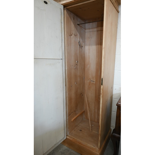 102 - A Continental pine compactum wardrobe, the central section with glazed doors over the open niche and... 