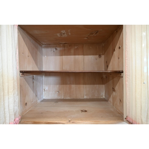 102 - A Continental pine compactum wardrobe, the central section with glazed doors over the open niche and... 