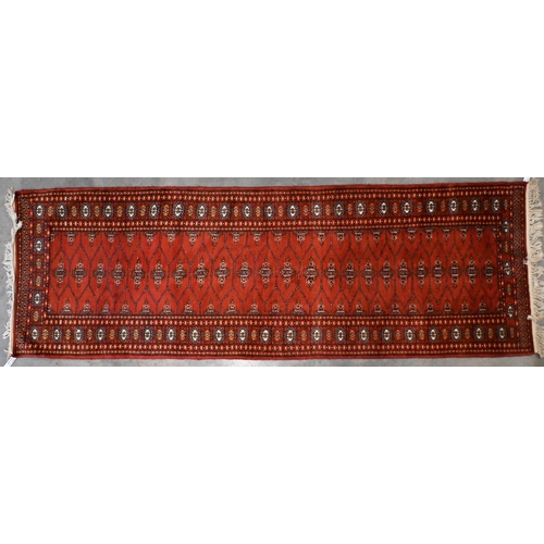 127 - A Pakistani Turkoman design red ground runner, 244 x 84 cm