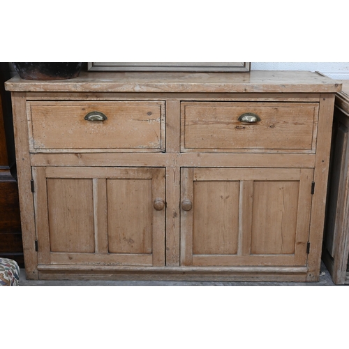 136 - An antique pine kitchen dresser base with two drawers over panelled cupboard doors (top with routed ... 