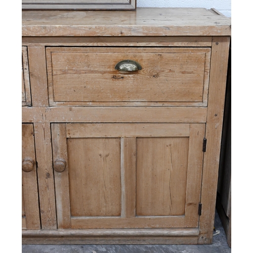 136 - An antique pine kitchen dresser base with two drawers over panelled cupboard doors (top with routed ... 