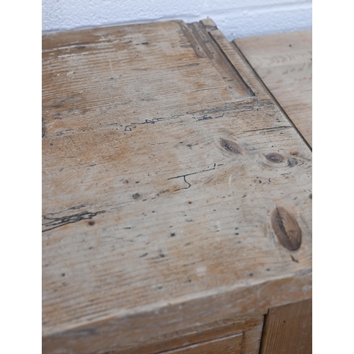 136 - An antique pine kitchen dresser base with two drawers over panelled cupboard doors (top with routed ... 