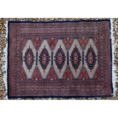 142 - Two Pakistani Turkoman design rugs, red and beige ground with repeating geometric guls, 152 x 94 cm ... 