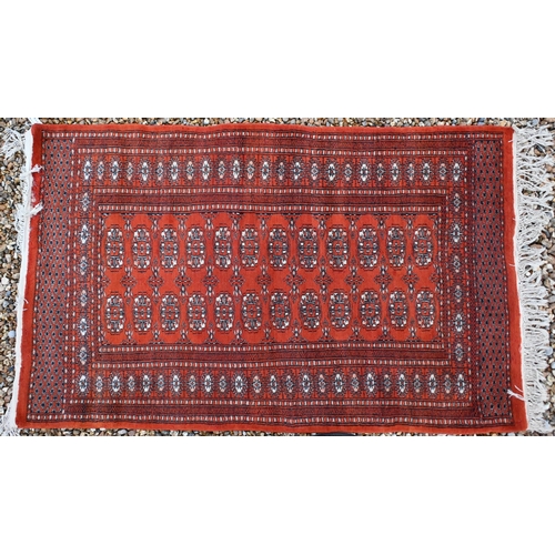 142 - Two Pakistani Turkoman design rugs, red and beige ground with repeating geometric guls, 152 x 94 cm ... 