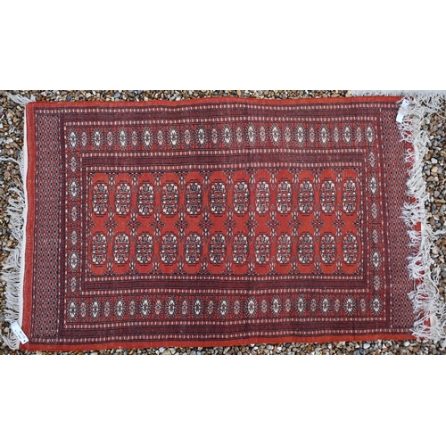 142 - Two Pakistani Turkoman design rugs, red and beige ground with repeating geometric guls, 152 x 94 cm ... 