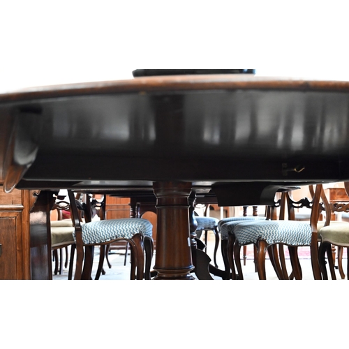 144 - A circular tilt-top mahogany crossbanded dining table on turned column and splayed legs with brass c... 