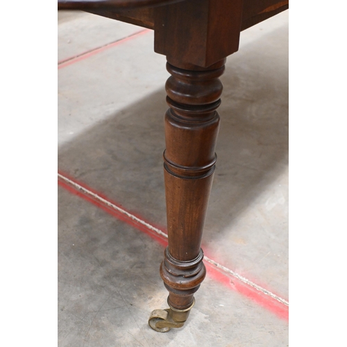 147 - A 19th century mahogany extending dining table with drop-leaf ends and two central leaves raised on ... 