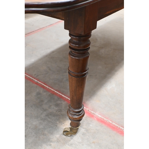 147 - A 19th century mahogany extending dining table with drop-leaf ends and two central leaves raised on ... 