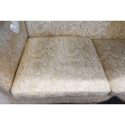 150 - A Knole two-seater sofa with old gold floral upholstery and turned hardwood finials, 192 x 90 x 100 ... 