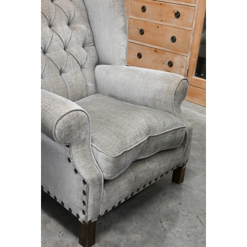 156 - A low-seated modern wing back armchair (reduced in height) upholstered in grey button back fabric wi... 