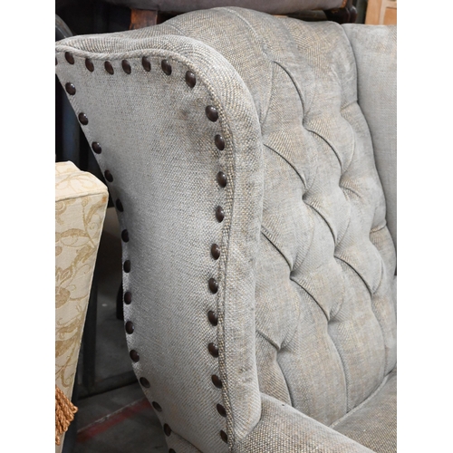 156 - A low-seated modern wing back armchair (reduced in height) upholstered in grey button back fabric wi... 