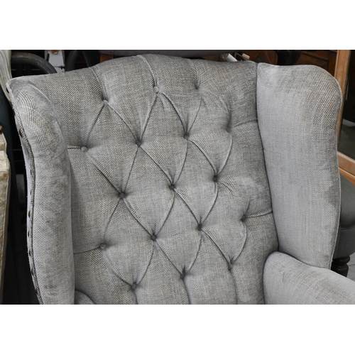 156 - A low-seated modern wing back armchair (reduced in height) upholstered in grey button back fabric wi... 