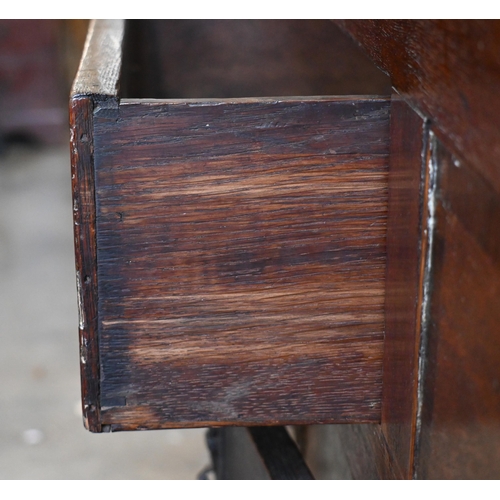 162 - An 18th century oak sideboard with seven drawers arranged around the pair of central cupboard doors ... 