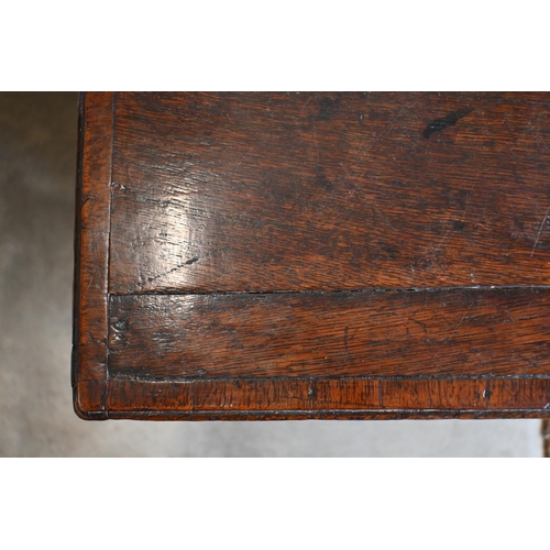 162 - An 18th century oak sideboard with seven drawers arranged around the pair of central cupboard doors ... 