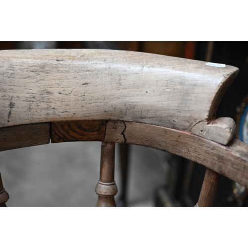 171 - An antique ash and elm spindle back captains chair, shaped seat and turned legs with stretchers