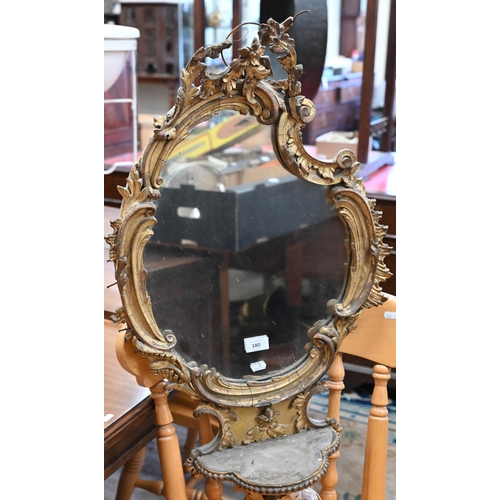 180 - An antique rococo mirror with giltwood and gesso floral and foliate frame and integrated shelf a/f, ... 