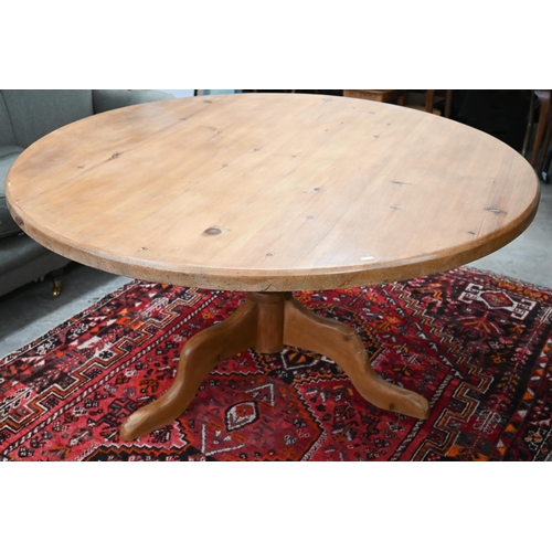 184 - A vintage circular pine dining table on turned column and triform supports, 134 cm diameter x 74 cm ... 