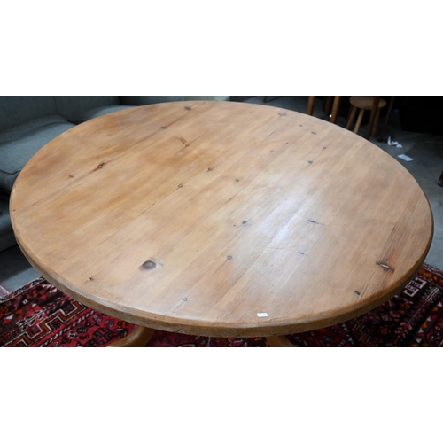 184 - A vintage circular pine dining table on turned column and triform supports, 134 cm diameter x 74 cm ... 