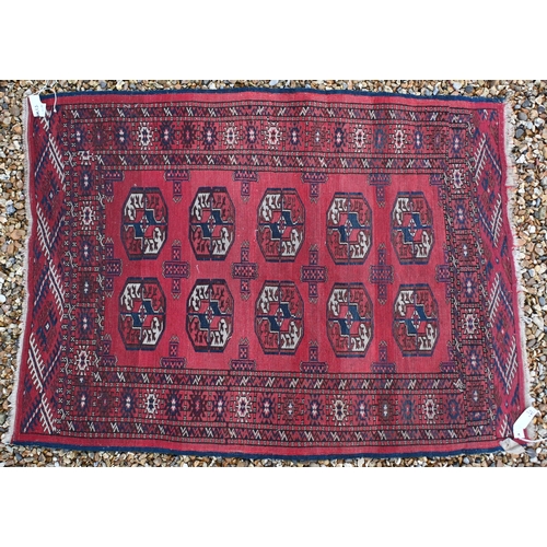 189 - A small Persian Turkman rug, with repeating gul design on red ground with multi-borders, 126 x 92 cm