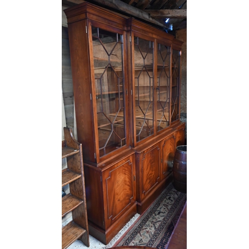 207 - A reproduction mahogany breakfront library bookcase with astragal glazed doors enclosing adjustable ... 