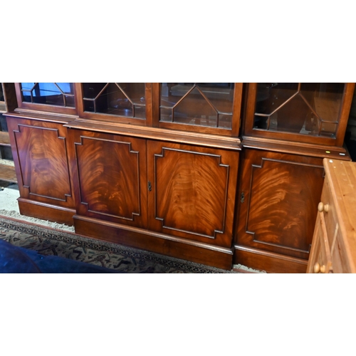 207 - A reproduction mahogany breakfront library bookcase with astragal glazed doors enclosing adjustable ... 