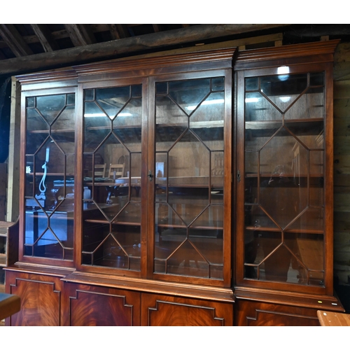 207 - A reproduction mahogany breakfront library bookcase with astragal glazed doors enclosing adjustable ... 