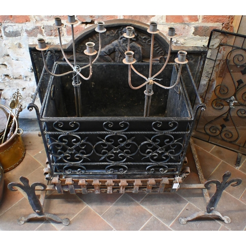 21 - A traditional cast iron fireback mounted to a wrought iron fire basket with integral firedogs to/wit... 