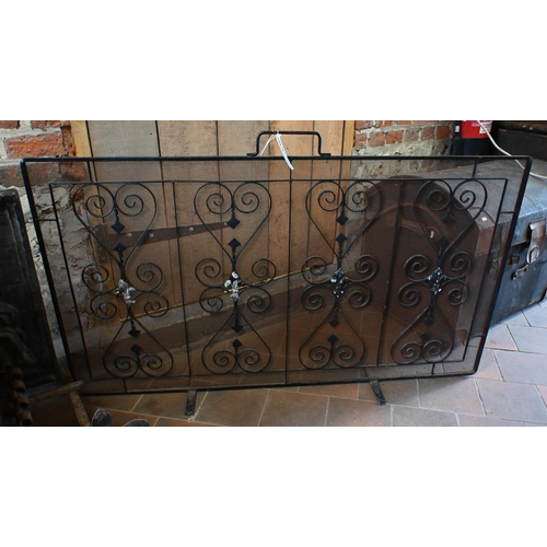 21 - A traditional cast iron fireback mounted to a wrought iron fire basket with integral firedogs to/wit... 