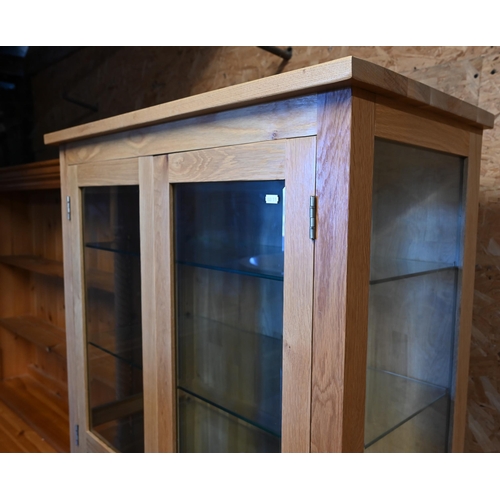 210 - A modern light oak part glazed light-up display cabinet with adjustable shelving and two drawers, 90... 