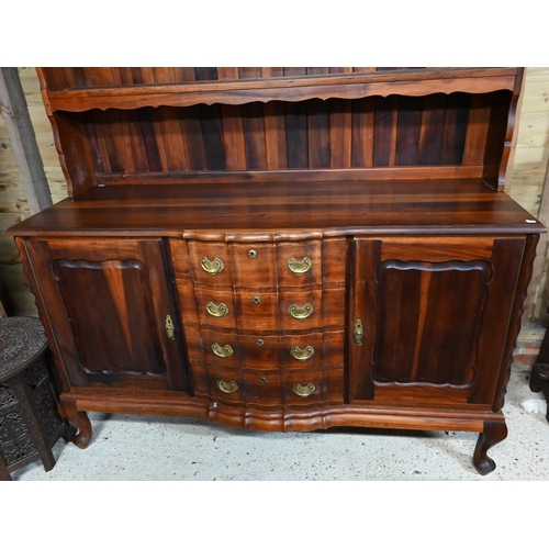 25 - A South African stinkwood dresser, the open rack over a base centred by four drawers, on short cabri... 