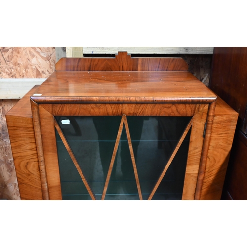 31 - An Art Deco walnut display cabinet, the glazed in door and side panels enclosing glass shelves