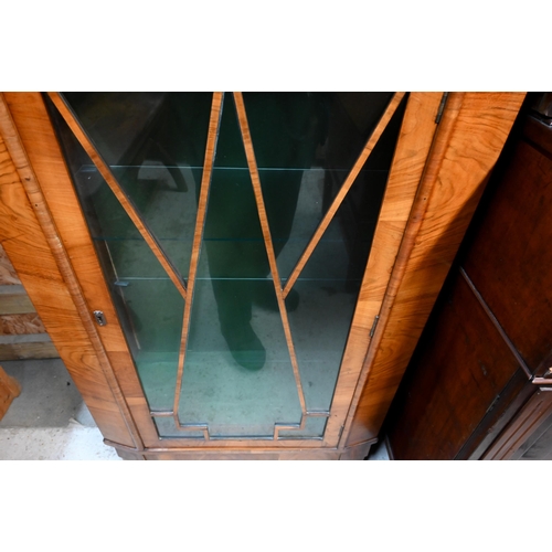 31 - An Art Deco walnut display cabinet, the glazed in door and side panels enclosing glass shelves