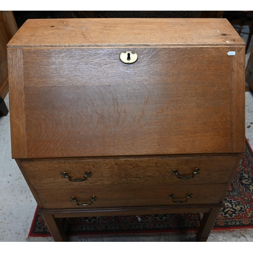 32 - # A golden oak fall front bureau over two drawers and raised on an open base