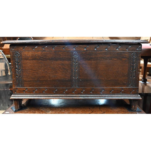 47 - An old part carved oak coffer, raised on shaped bracket sleigh ends