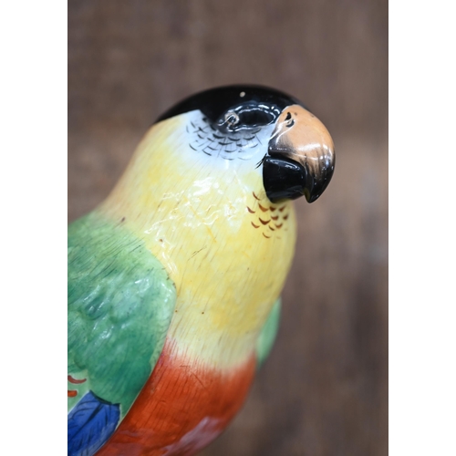 504 - A Continental porcelain model of a parrot perched on a branch, raised on a rocky base, underglaze 'R... 