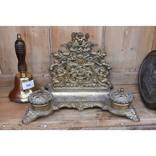 506 - An oval brass plaque cast with a Royal crown to/w a brass inkstand/stationery rack, a brass hand-bel... 