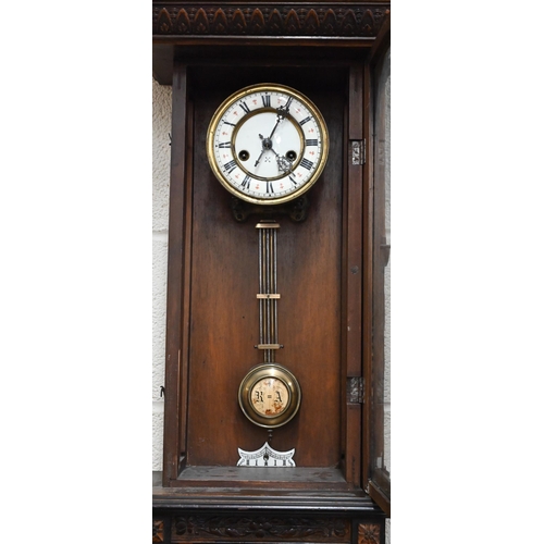 530 - # A German carved walnut Vienna-style wall clock, 98cm high