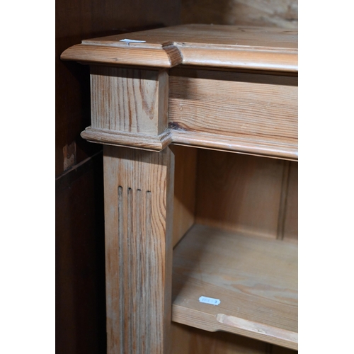 57 - A modern pine low open bookcase with two adjustable shelves, on a plinth base