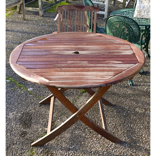 6 - A weathered teak garden table and four folding chairs (5)