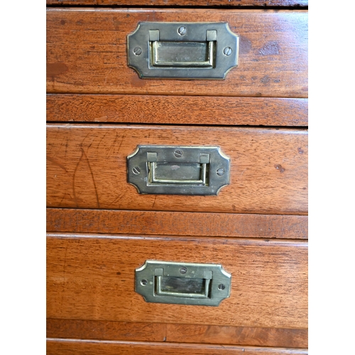 77 - A teak and brass mounted campaign style chest with arrangement of ten drawers with recessed handles,... 