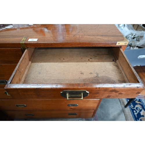 77 - A teak and brass mounted campaign style chest with arrangement of ten drawers with recessed handles,... 