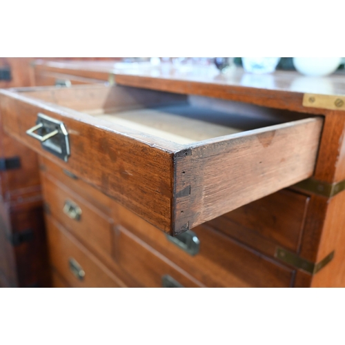 77 - A teak and brass mounted campaign style chest with arrangement of ten drawers with recessed handles,... 