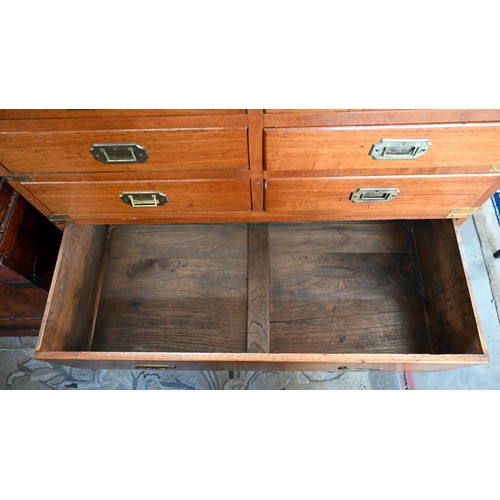 77 - A teak and brass mounted campaign style chest with arrangement of ten drawers with recessed handles,... 